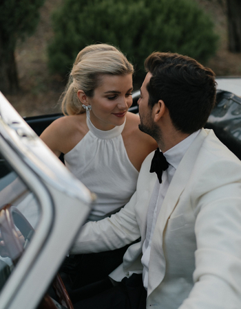 Bride and groom in a car at a luxury destination wedding at La Foce, Tuscany, Italy